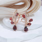 boucles d'oreilles en forme de fleur avec des zircons rouges